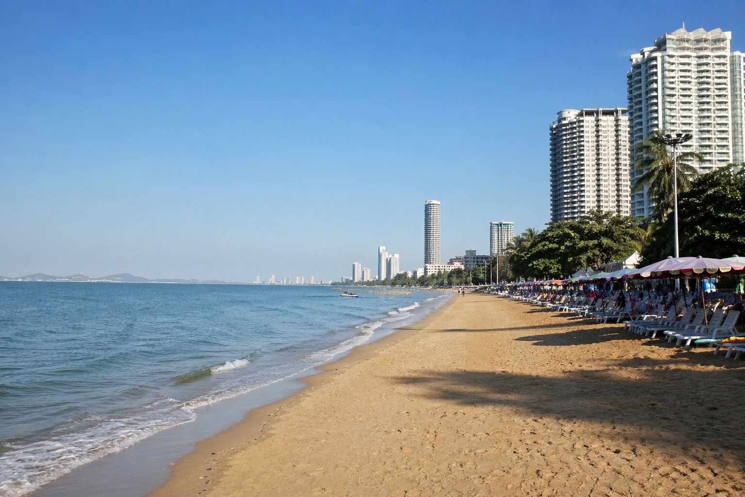 Пляж Джомтьен в Паттайе с шезлонгами и кондоминиумами вдоль побережья