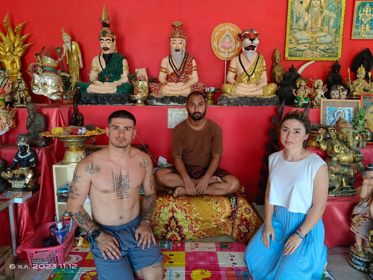 Аджан наносит традиционную татуировку Сак Янт бамбуковой палочкой - священные татуировки в Таиланде