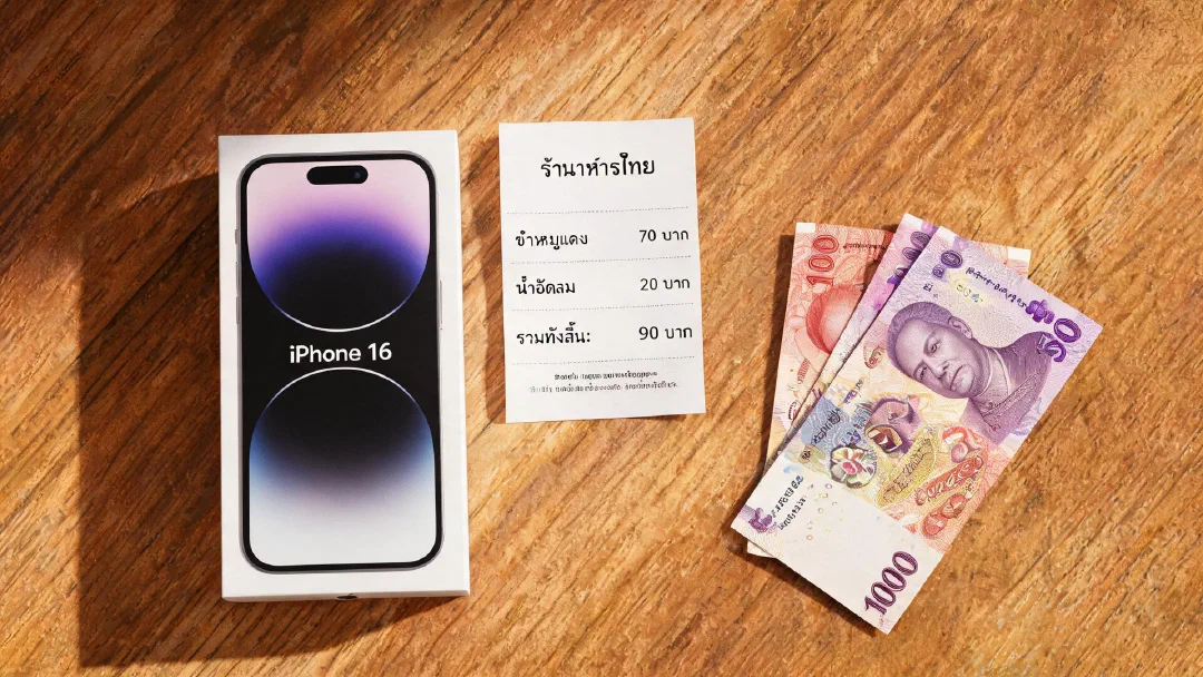 Коробка iPhone 16 рядом с тайскими батами и чеком