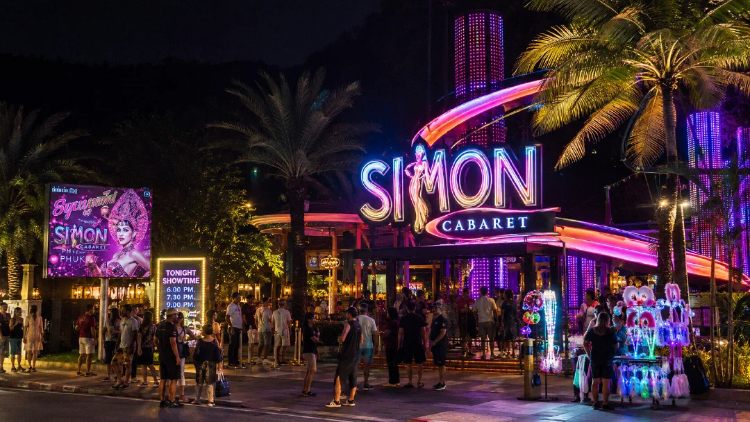 Вход в Simon Cabaret на Пхукете ночью — неоновые вывески и туристы